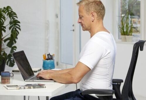 Man in a Posture Shirt works in an inactive position